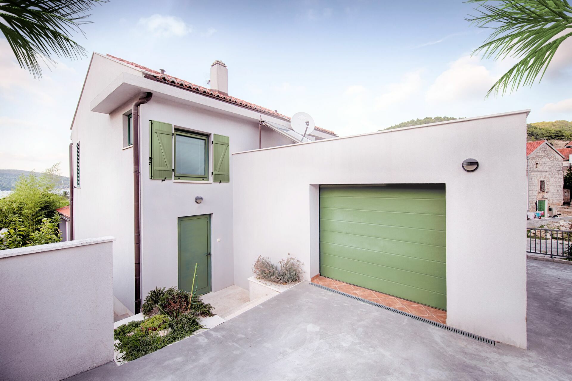 Volet-battant-pvc-lames-clipsees-collees-24-mm-et-porte-de-garage-sectionnelle-a-refoulement-plafond-en-acier-isole-motorisee-standard-min